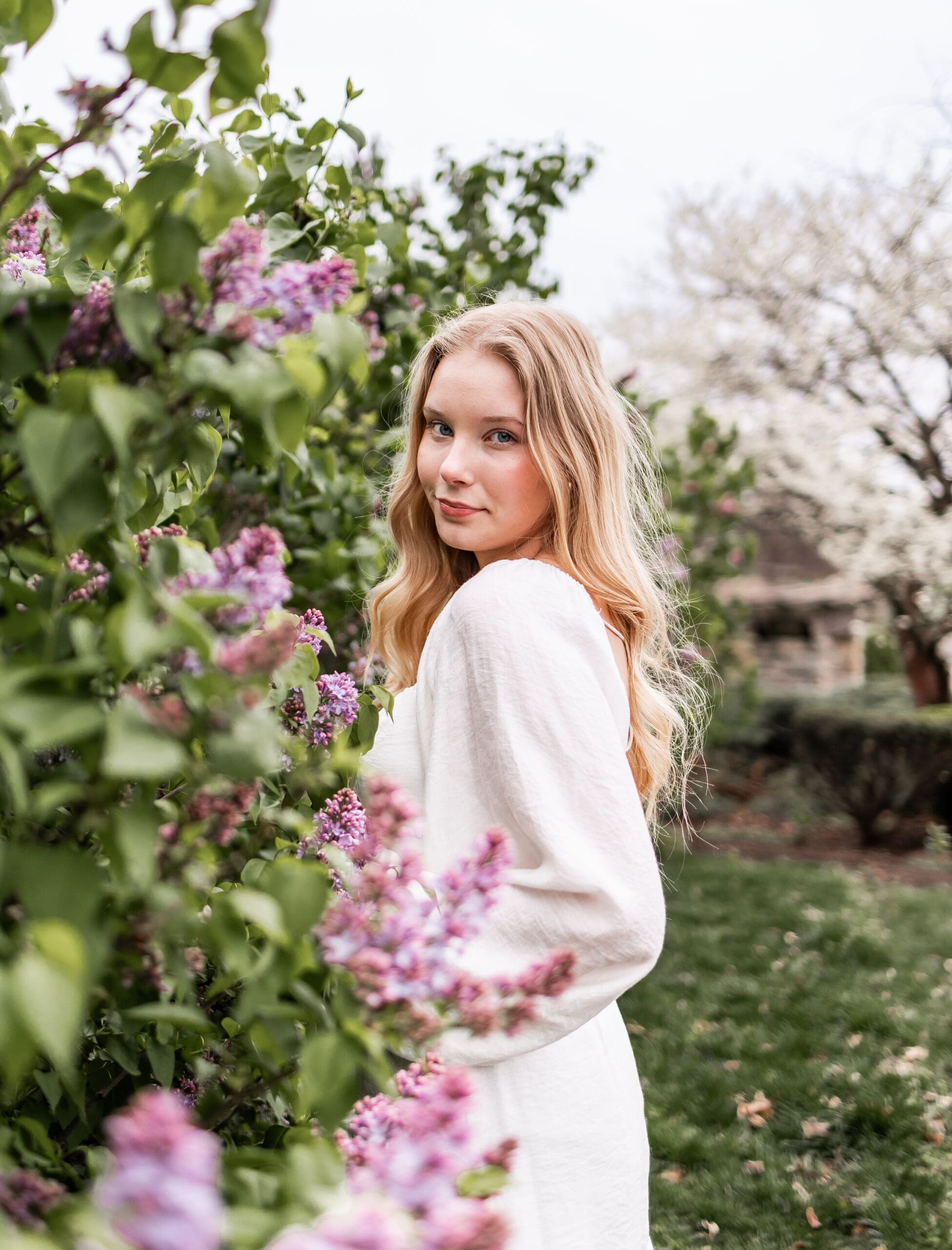 Young blonde girl next to a flowered bush at Loose Park in Kansas City, Missouri